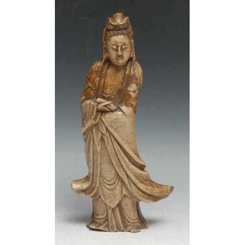 303 - A Chinese soapstone figure, carved as Guanyin, she stands, holding a scroll, 26cm high, 19th century