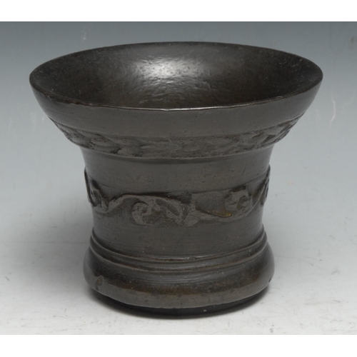 2 - A 16th century bronze bell shaped mortar, cast with a band of leafy scrolls, 12cm diam, c.1550-1600