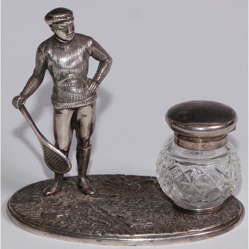 462 - A silver plated novelty inkstand, as a gentleman dressed for tennis, glass well, 12.5cm wide