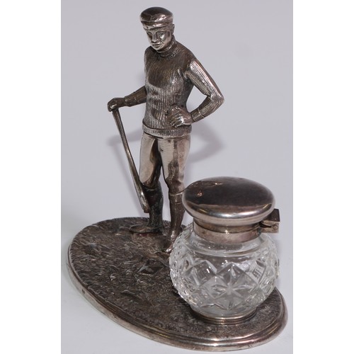 462 - A silver plated novelty inkstand, as a gentleman dressed for tennis, glass well, 12.5cm wide