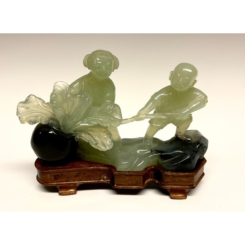 289 - A Chinese hardstone carving, of a girl and boy with a peach, hardwood stand, 18cm wide