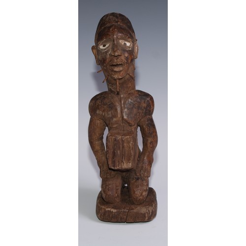 722 - Tribal Art - a Kongo power figure (nkondo nkisi), the fetish figure kneels, the chin and cheeks pier... 