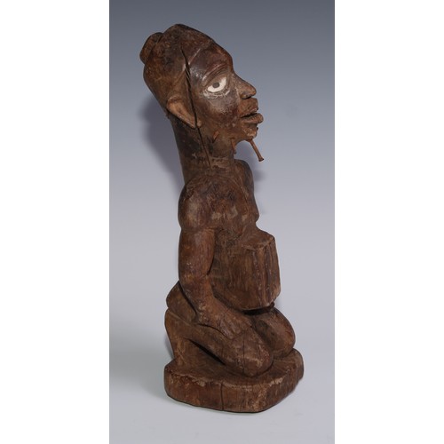 722 - Tribal Art - a Kongo power figure (nkondo nkisi), the fetish figure kneels, the chin and cheeks pier... 