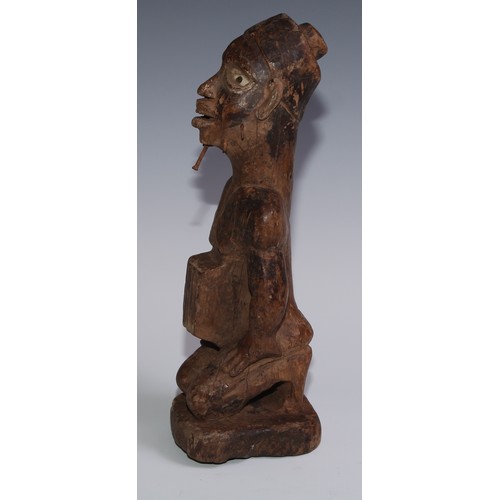 722 - Tribal Art - a Kongo power figure (nkondo nkisi), the fetish figure kneels, the chin and cheeks pier... 