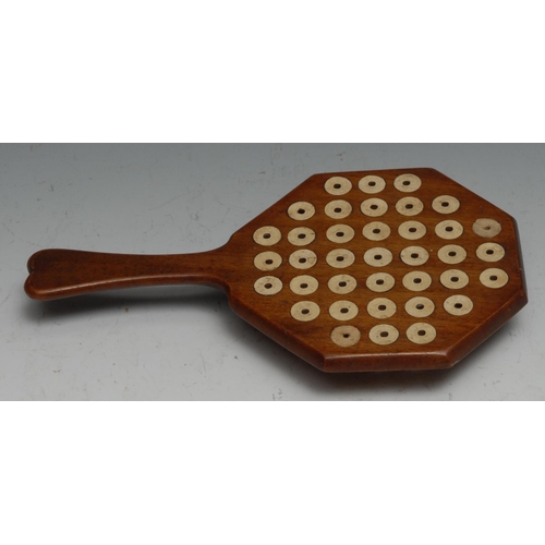 155 - Folk Art - a mahogany pan-handled solitaire board, the base with compartment enclosing bone pegs, 22... 