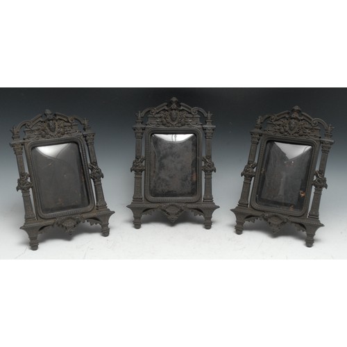 459 - A set of three 19th century Renaissance Revival bois durci easel photograph frames, each in relief w... 