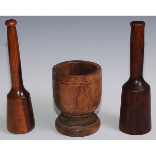 243 - Treen - a 19th century lignum vitae pestle, 27cm long; another pestle; a turned lignum vitae mortar,... 