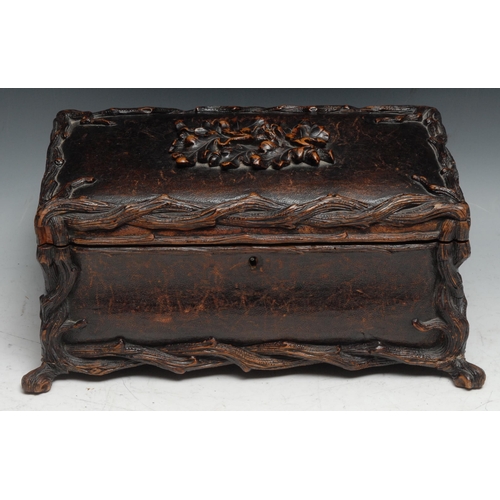 137 - A large Black Forest rectangular bombe shaped table casket, leather clad and carved with rustic bran... 