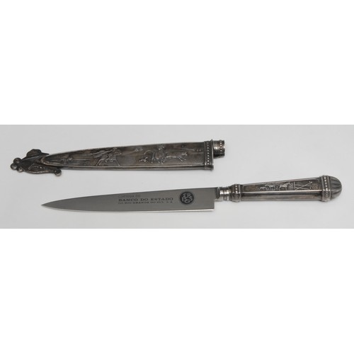 741 - A South American silvered metal gaucho knife, the hilt and sheath in relief with cattle, horses and ... 