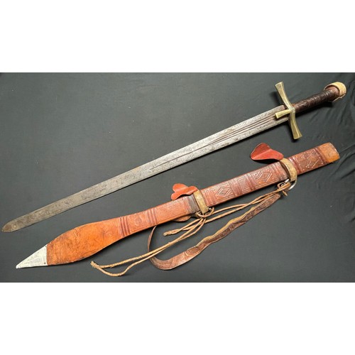 3085 - A Sudanese Kaskara sword with double edged blade 855mm in length. Brass crossguard. Leather bound gr... 