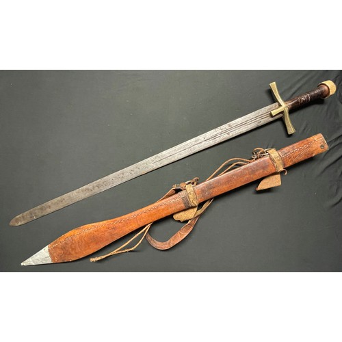 3085 - A Sudanese Kaskara sword with double edged blade 855mm in length. Brass crossguard. Leather bound gr... 