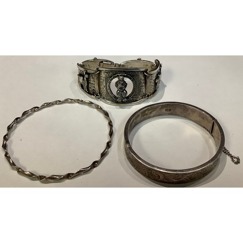 599 - A silver bangle, Chester 1962; a silver coloured metal bracelet; another (3)