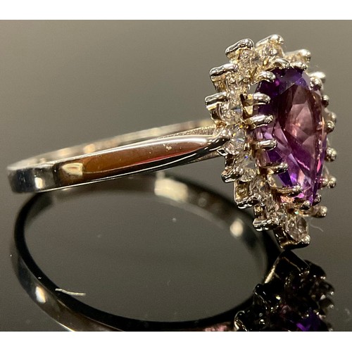 642 - A 9ct white gold ring, the central pear cut amethyst surrounded by brilliant cut cubic zirconia, siz... 