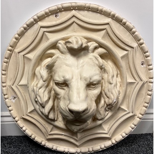 121 - A large circular plaster plaque, bead and reel border centred by a lion mask boss, 59cm diameter