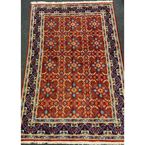 56 - A Persian Mashad hand-knotted rug / carpet, having a central field in rich red and Lapis blue, with ... 