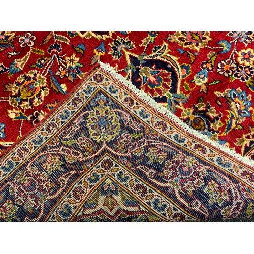 61 - A Kashan rug / carpet, hand-knotted in rich tones of red, cream, indigo, and blue, 202cm x 134cm.