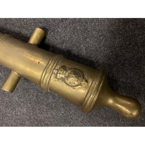 73 - A replica brass cannon barrel, cast with coat of arms, 79cm long