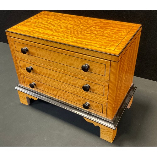 74 - A satinwood miniature chest, three long drawers, bracket feet, 33cm high, 39cm high