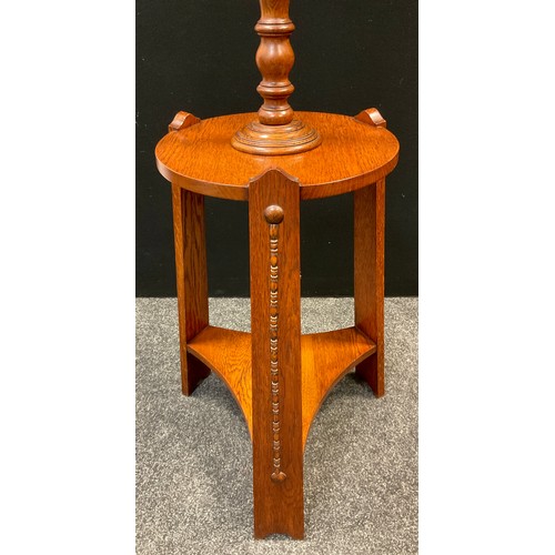 125 - An Arts and Crafts oak table standard-lamp, turned lamp column to top, circular tripod table base, 1... 