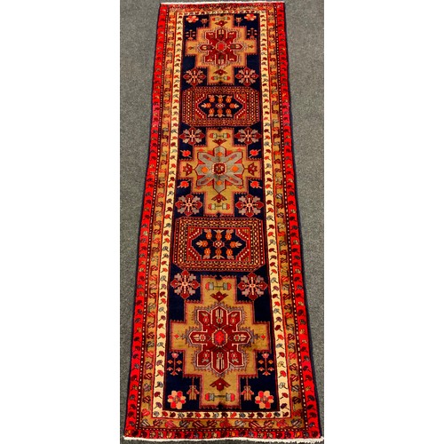 135 - An Azerbaijan runner carpet, hand-knotted in red, cream, and deep blue, 332cm x 109cm.