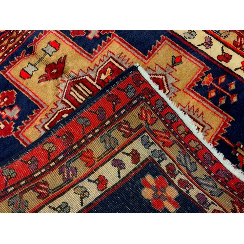 135 - An Azerbaijan runner carpet, hand-knotted in red, cream, and deep blue, 332cm x 109cm.