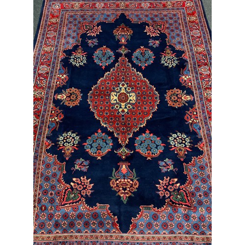 141 - A Hamadan rug / carpet, hand-knotted in rich blue, red, white, and pale blue, 318cm x 212cm.