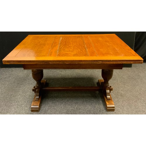 143 - A mid 20th century oak draw-leaf trestle dining table, 77.5cm tall x 98.5cm wide x 133cm long (211cm... 