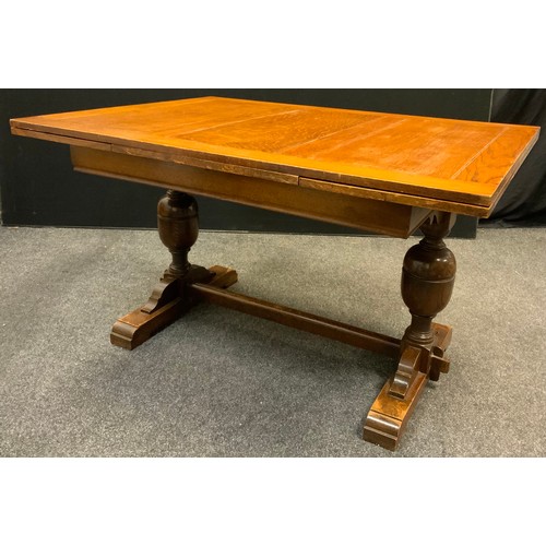 143 - A mid 20th century oak draw-leaf trestle dining table, 77.5cm tall x 98.5cm wide x 133cm long (211cm... 