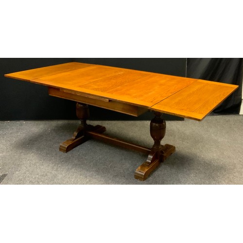 143 - A mid 20th century oak draw-leaf trestle dining table, 77.5cm tall x 98.5cm wide x 133cm long (211cm... 