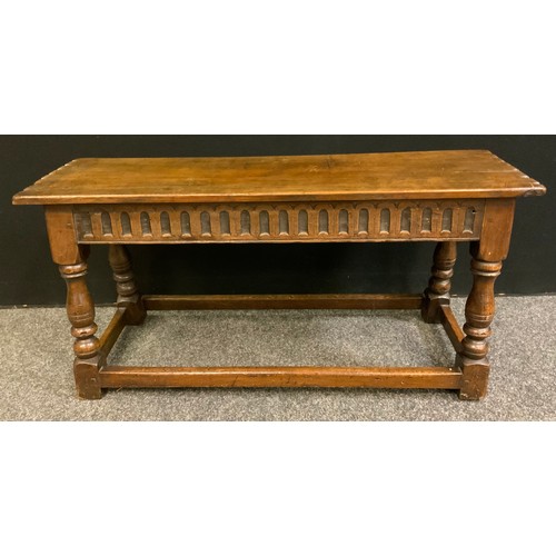 124 - A 19th century oak long stool, rectangular over-sailing top, cut detailing, carved frieze, turned su... 