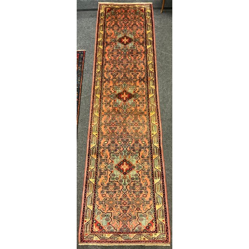 297 - A Rudbar Runner carpet, hand knotted in soft tones of red, pink, cream, and blue, with a row of thre... 