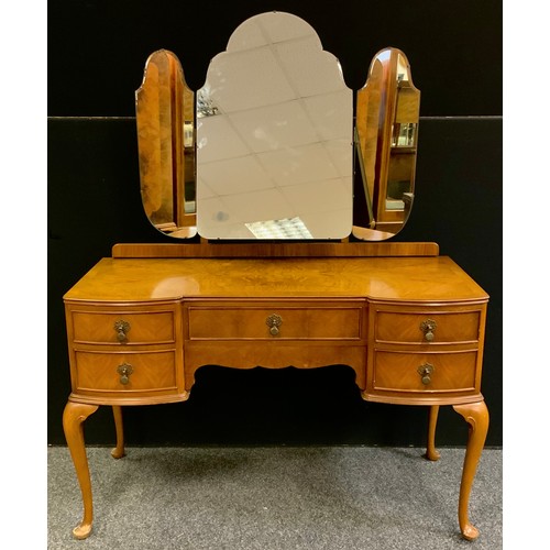 315 - An Art Deco style walnut dressing table, triple mirrored back, above an arrangement of five drawers,... 