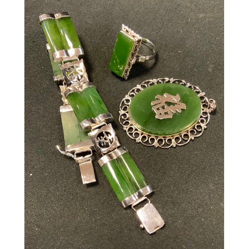 456 - A modern Chinese Green stone possibly jade bracelet, pendant and ring suite, mottled tones, silver c... 