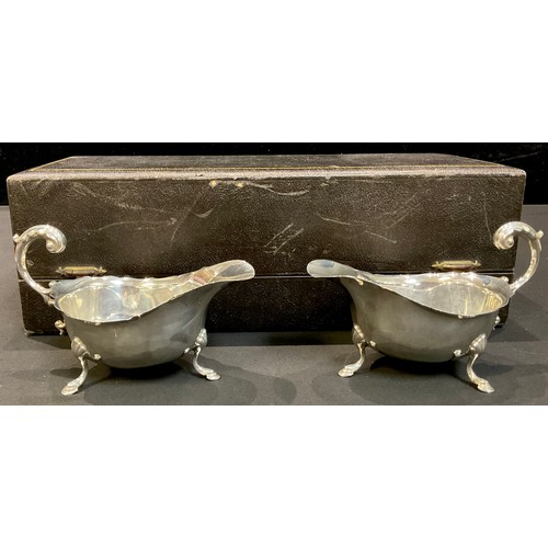 188 - A pair of George V silver sauce boats, acanthus capped scroll handles, each resting on three pad fee... 