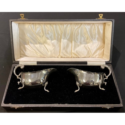 188 - A pair of George V silver sauce boats, acanthus capped scroll handles, each resting on three pad fee... 