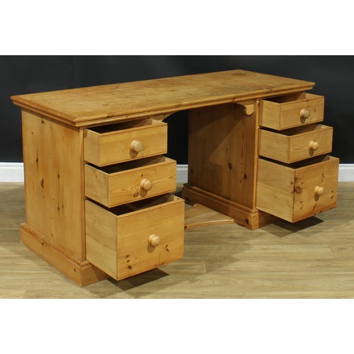 107 - A pine desk, rectangular top above an arrangement of drawers, 76.5cm high, 152.5cm wide, 61cm deep