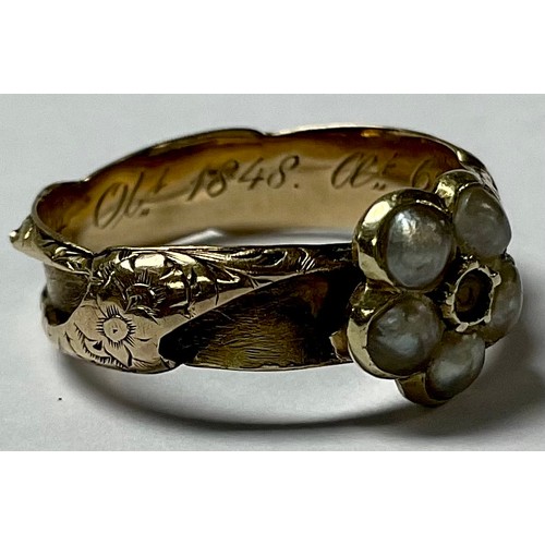 551 - A 19th century unmarked gold mourning ring, set with a five stone seed pearl flowerhead, the interio... 