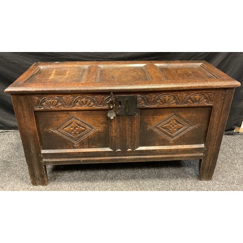 111 - An 18th century oak blanket chest, three panelled top, carved lunettes to frieze above two lozenges,... 