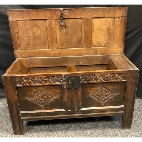 111 - An 18th century oak blanket chest, three panelled top, carved lunettes to frieze above two lozenges,... 