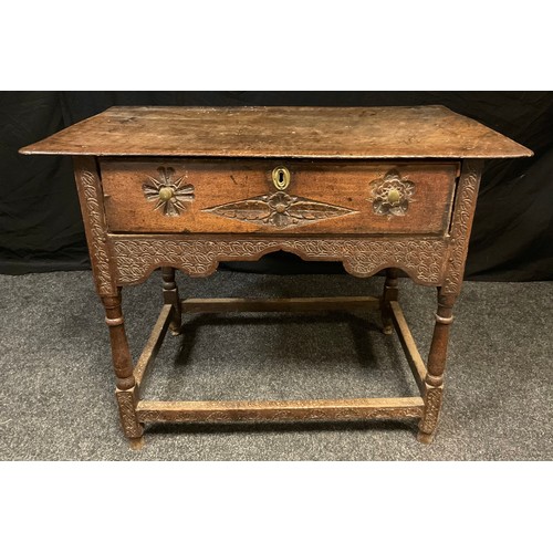 163 - An 18th century oak lowboy,  rounded rectangular over-sailing top,   turned supports, later carved, ... 