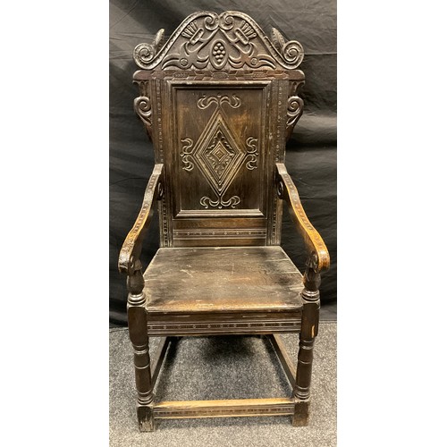 164 - An 17th century style  Wainscot chair, the back carved with scrolls and lozenge, scroll arms, solid ... 