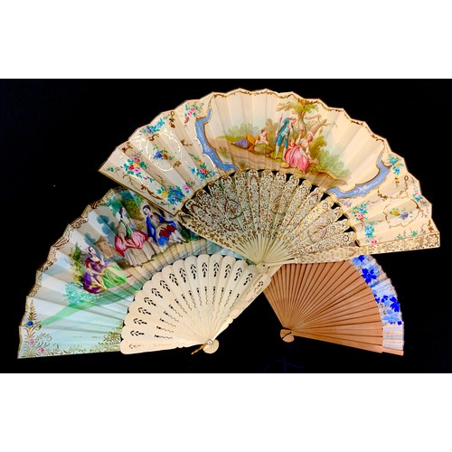 140 - A French fan, printed with figures in a country setting, and bone sticks, 42cm wide;  another;  etc