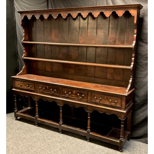 217 - A George III Oak Welsh Potboard Dresser, two tier plate rack top, over four short drawers, turned su... 