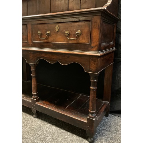 217 - A George III Oak Welsh Potboard Dresser, two tier plate rack top, over four short drawers, turned su... 