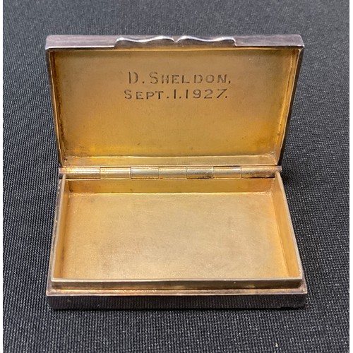 92 - A silver and enamel rectangular  snuff box, the cover embossed with  Haddon Hall, picked out in gree... 