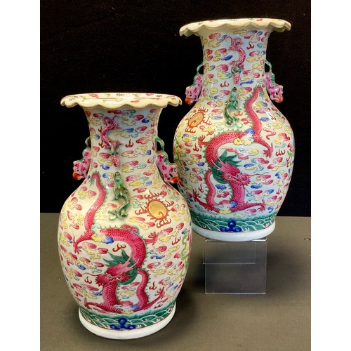 203 - A pair of Chinese Famille rose vases, decorated with dragons, dogs-of-foe and clouds, shi-shi handle... 