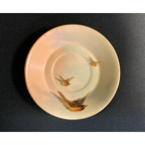 143 - A Royal Worcester miniature coffee cup and saucer, decorated  with British birds in flight on a blus... 