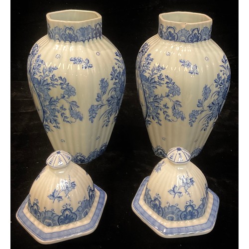 47 - A pair of blue and white Delft baluster vases and covers, each decorated with panels of windmills an... 