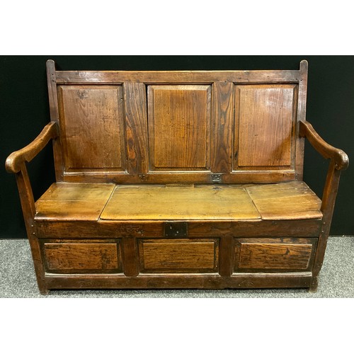 183 - A George III oak settle, three panel back, sloping arms, chest seat with single lift-up lid, three p... 