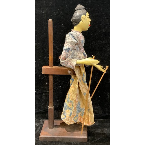 81 - An Indonesian Wayang Golek puppet, on stand, 55cm high overall